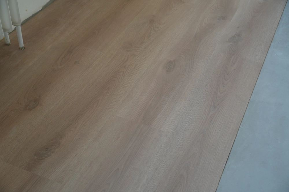 Nahaufnahme eines verlegten Holzdekor-Vinylbodens in hellem Grau – Vinylboden verlegen