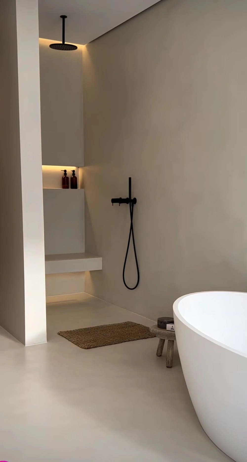 Minimalistisches Badezimmer mit bodengleicher Dusche, integrierter Sitzbank und freistehender Badewanne – Badsanierung