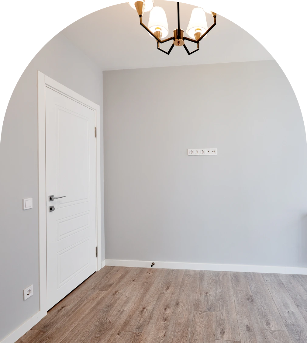 Renoviertes Zimmer mit frisch verlegtem Laminatboden, grauen Wänden, weißer Tür und Deckenleuchte, Laminat verlegen