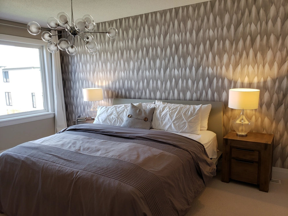 Modernes Schlafzimmer mit gemusterter Wandtapete, Bett, Nachttischen und Lampen – Tapezieren